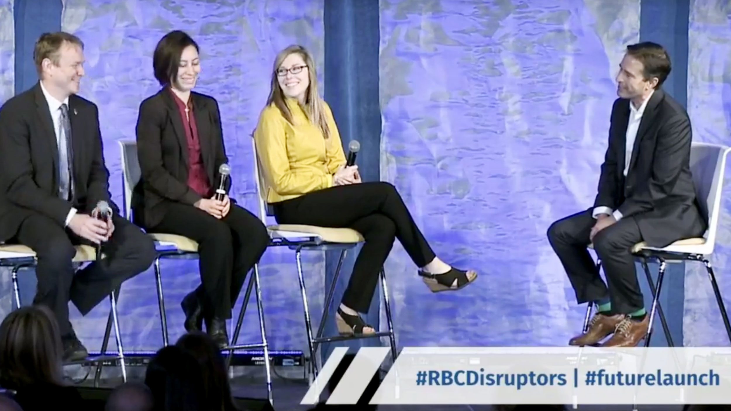 Evan, Leah and Amberley on stage with John Stackhouse with RBC graphic over