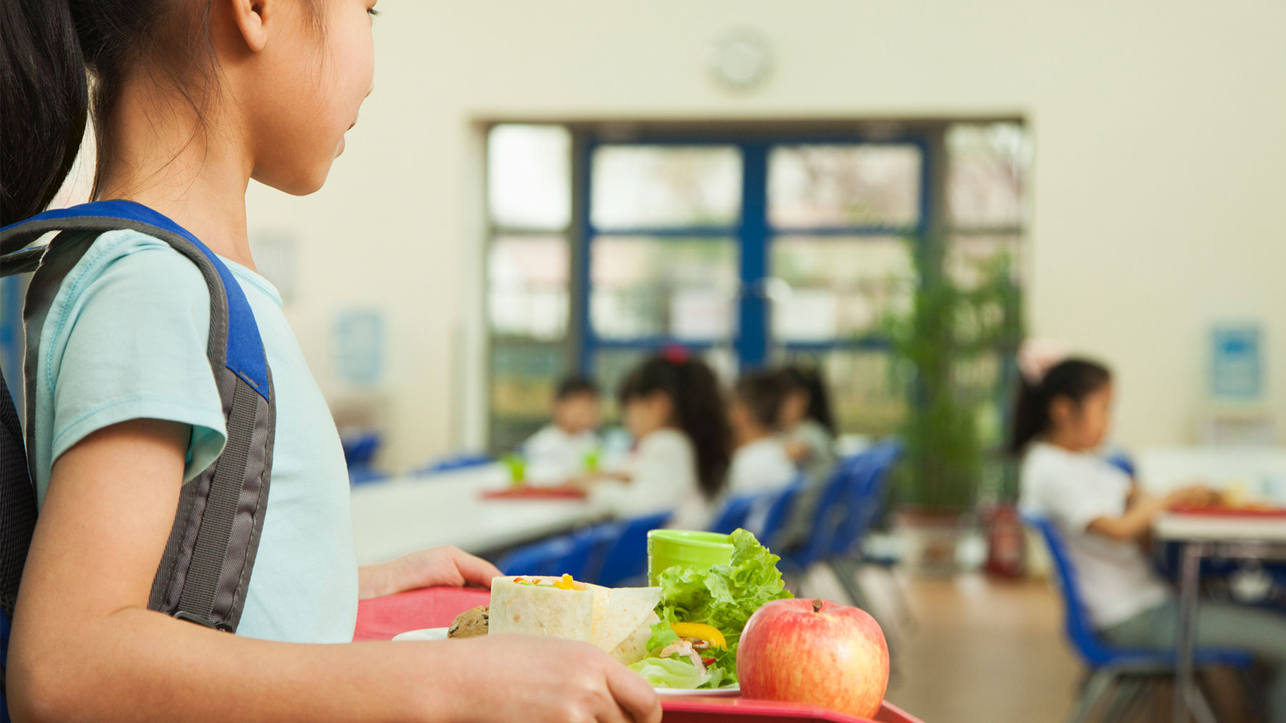 Girl carries a lunch tray in the cafeteria