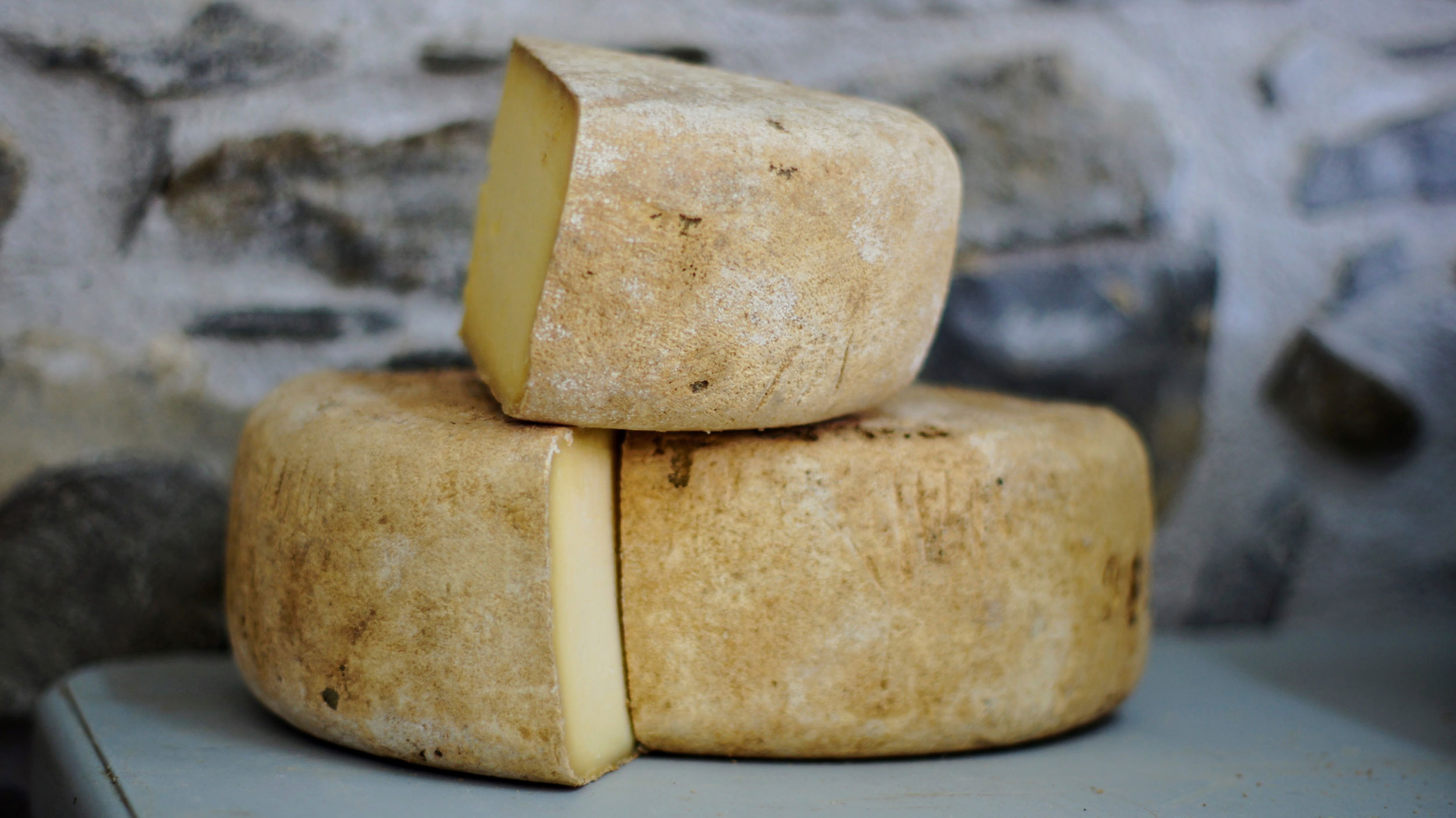 Half slices of cheese wheels stacked on each other.
