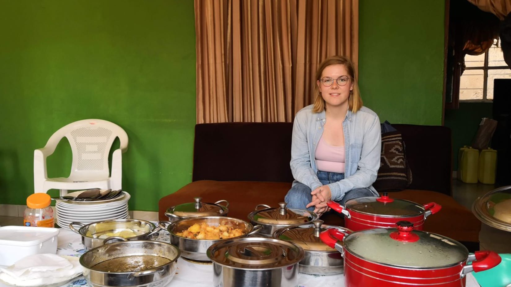 Regan poses behind a table covered in pots of food.