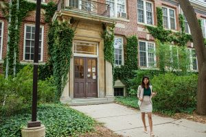 Arrell Scholar Sugandha walks away from an ivy covered campus building