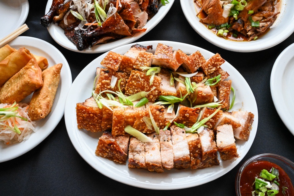 Lunar New Year platter featuring various plates of chinese food including egg roll, pork belly, and duck. 